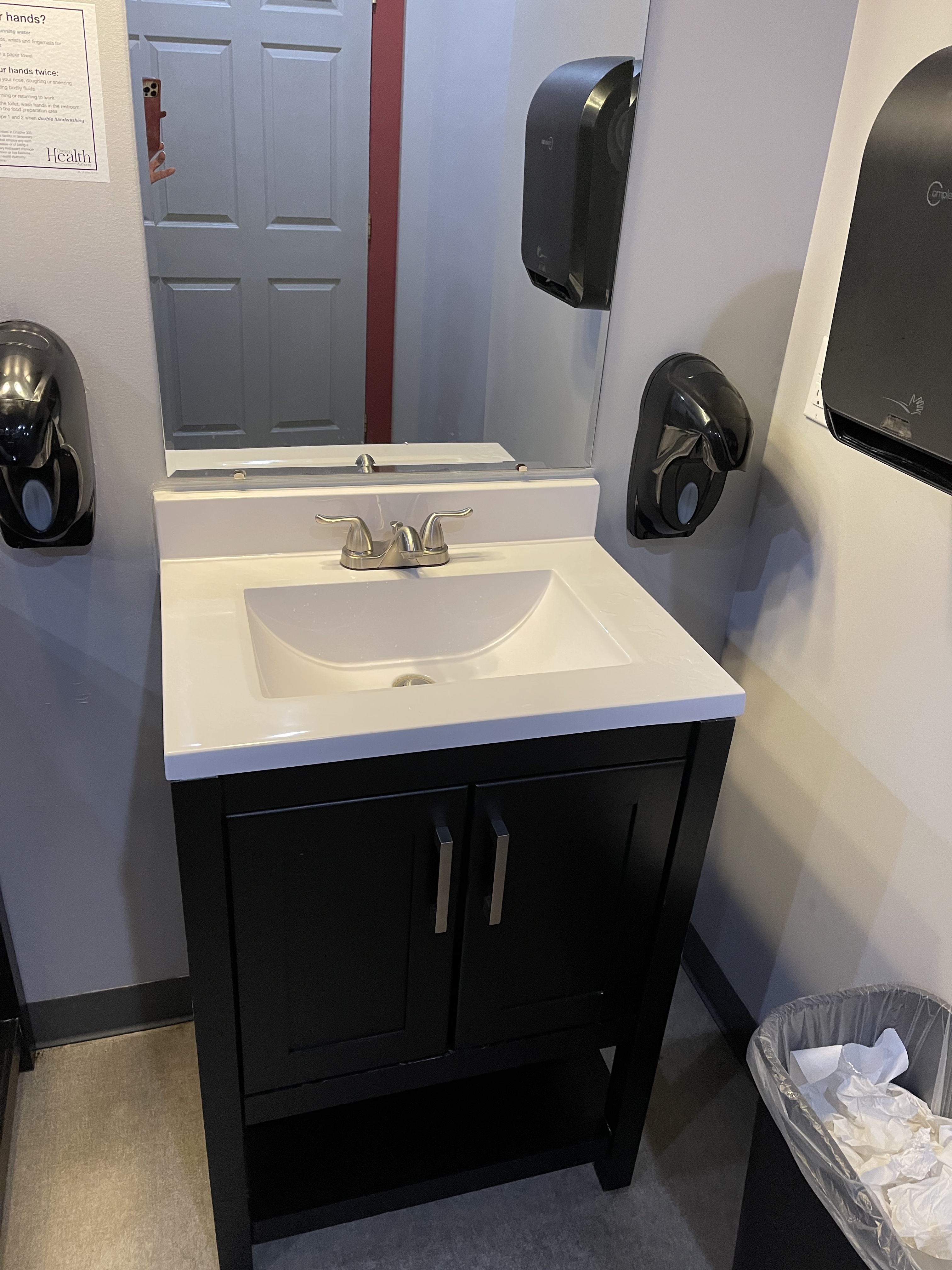 Photo shows sink with cabinet beneath, no room to roll under. Soap dispensers and towels are low enough to reach from a sitting position