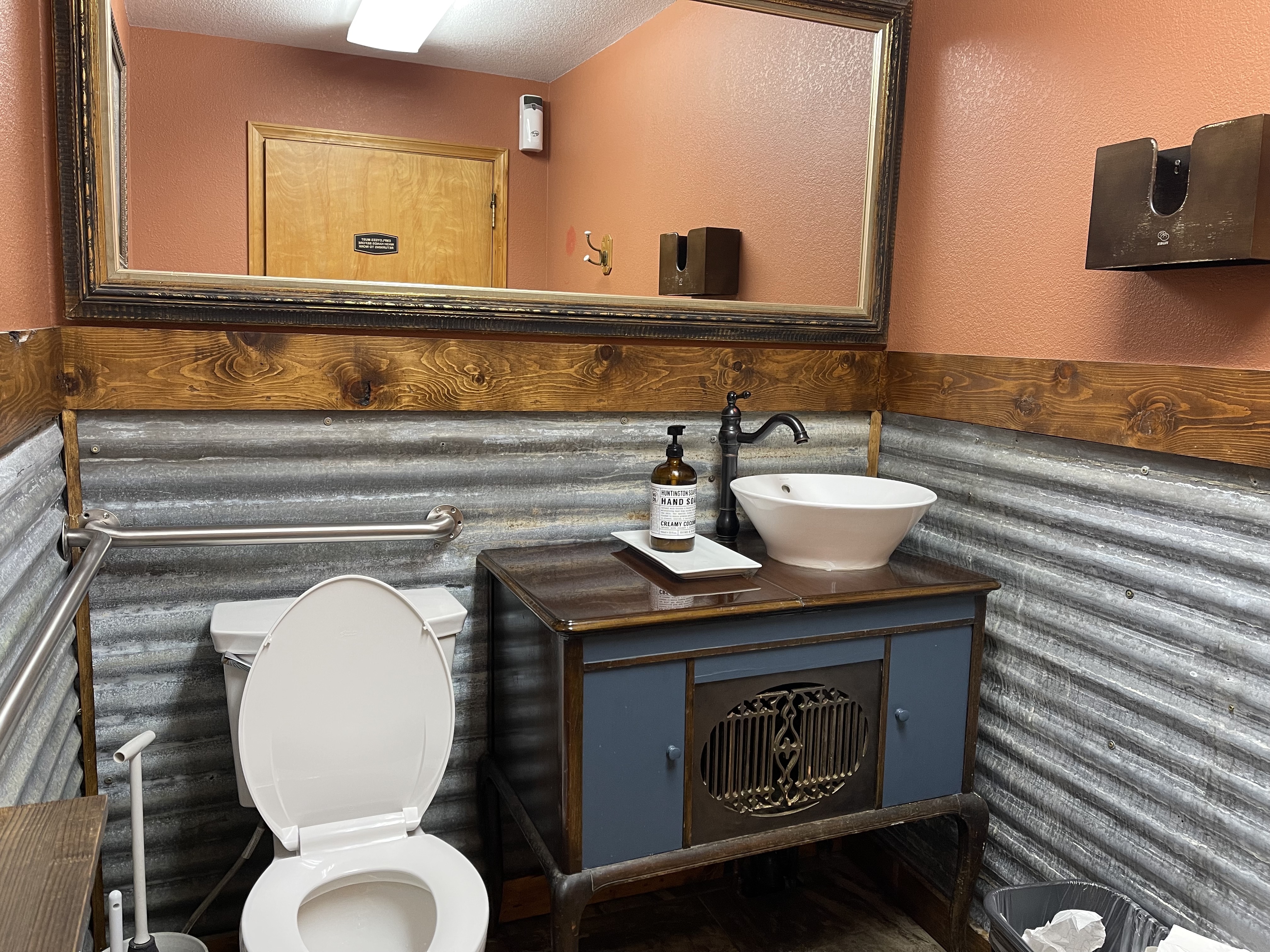 Inside of restroom, cabinet prevents rolling under sink. Towels in wooden holder up too high