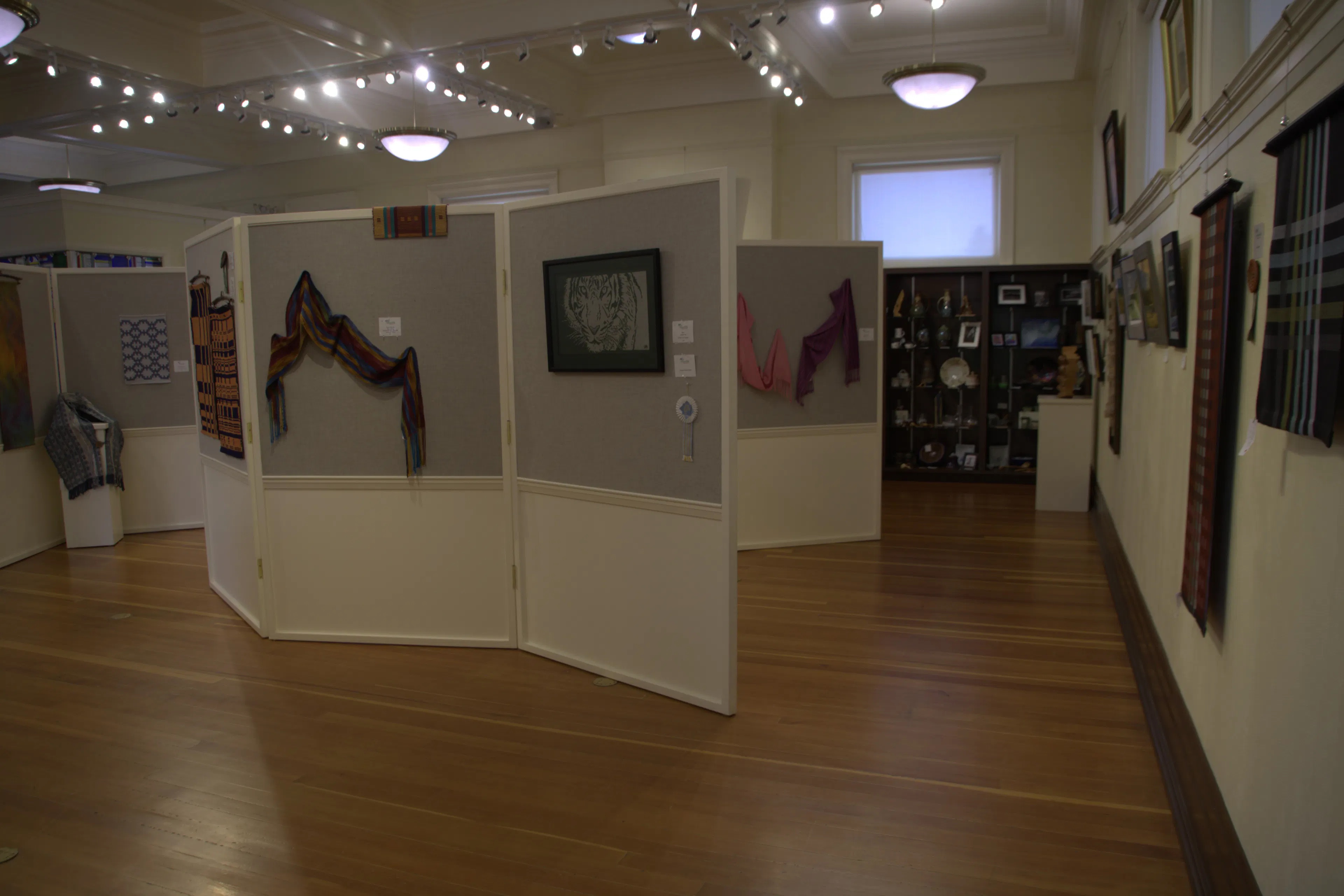 Carnegie Art Center art gallery. White panel walls with art hung at 4 to 5 feet.
