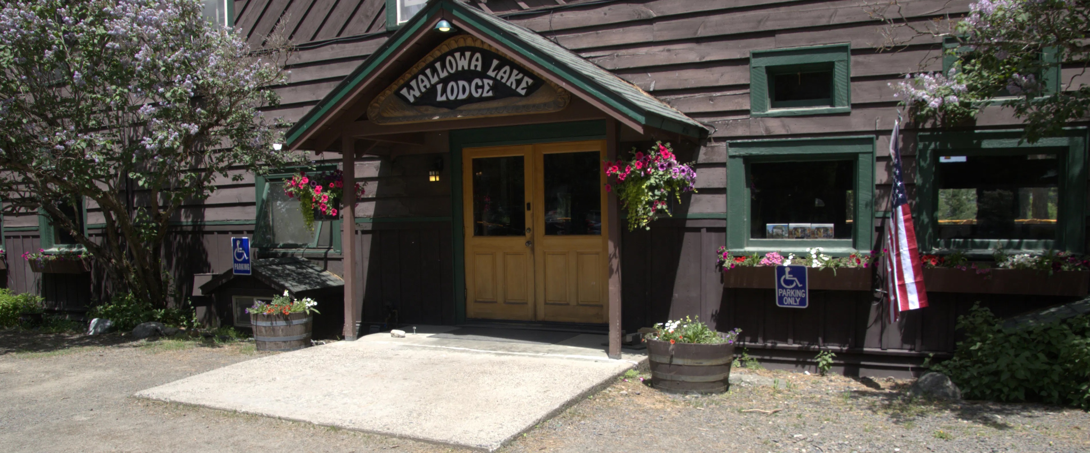 Gravel parking lot. One designated accessible space on either side of door to lodge. French doors with 2