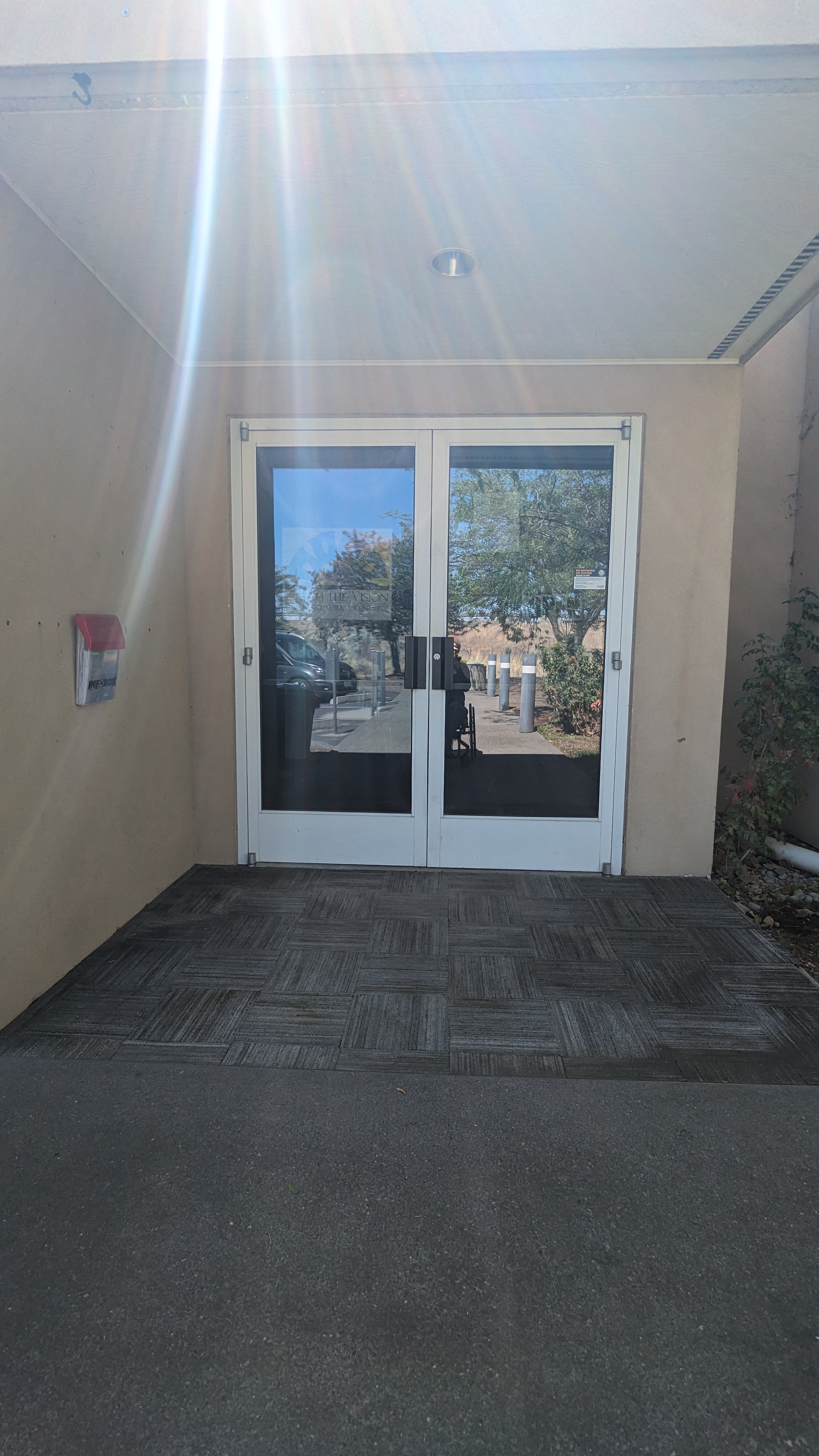 Paved sidewalk to sturdy mats with no threshold between, double glass doors.