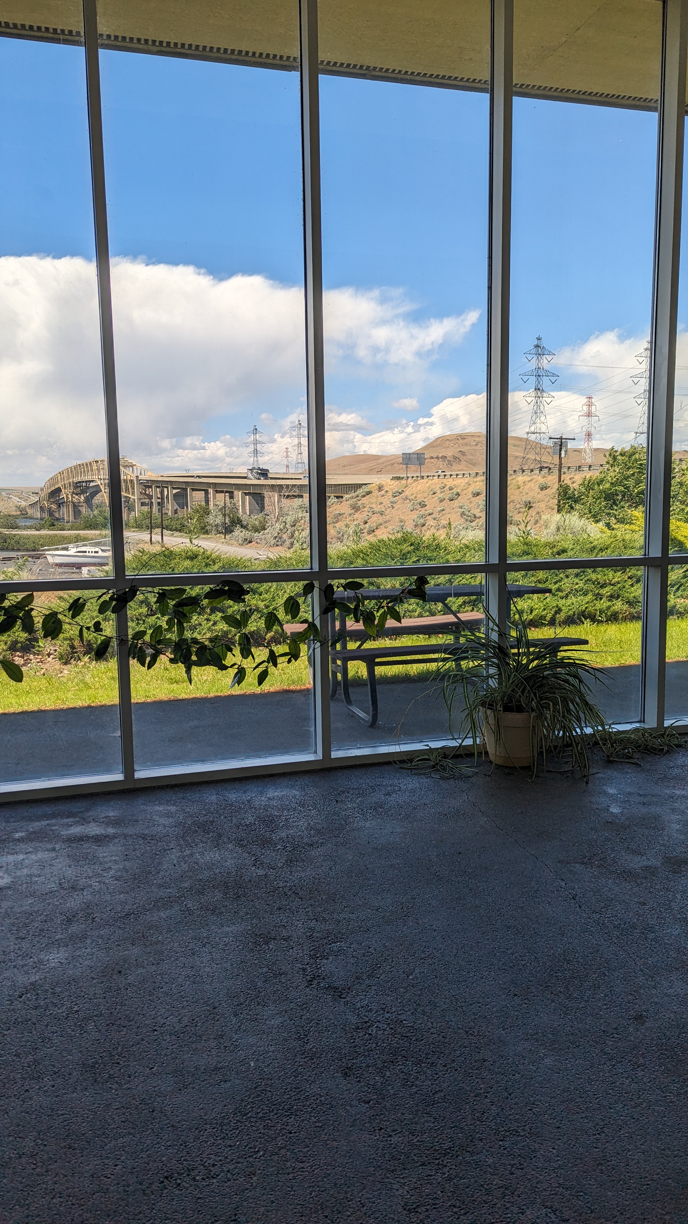 Open space with large floor to ceiling windows on one whole wall, waist high break in window framing.