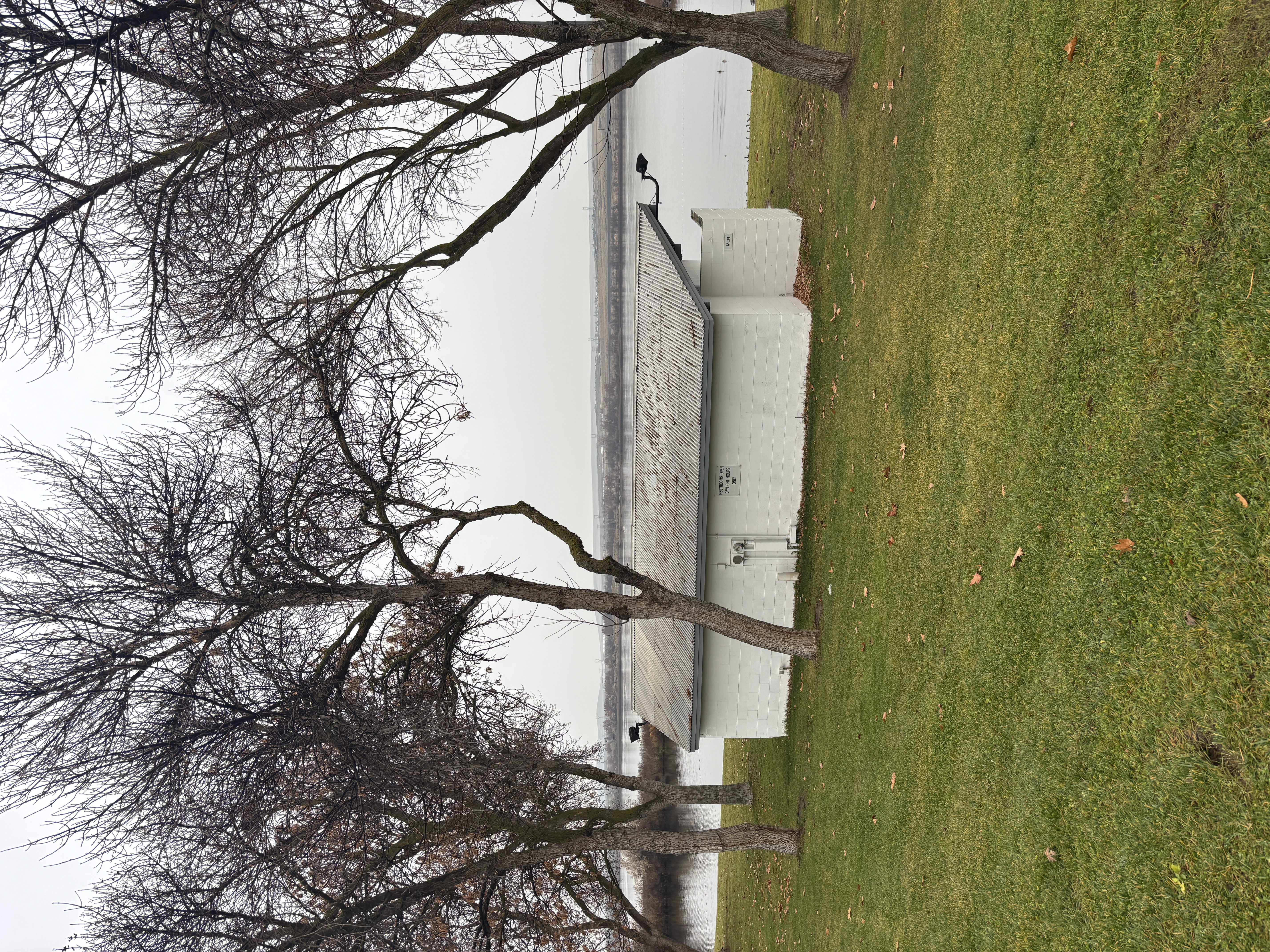 View from parking lot. No marked parking. Small curb from parking lot meets grass. A concrete sloped access can be found on the corner.